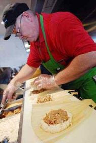 employee hand rolling Tucson Tamale tamales